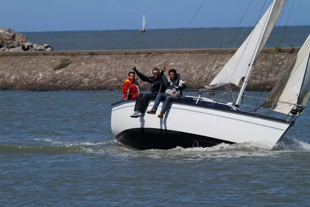 Sortie en voilier Gravelines — équipage sur le chenal de l'Aa Équipage de voilier saluant depuis le chenal de l'Aa, vu du gîte Bouteille à la Mer à Gravelines