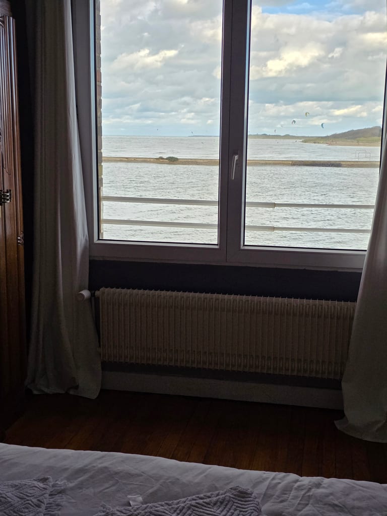 Vue imprenable sur le chenal et la mer, animée au loin par des kitesurfeurs, depuis la fenêtre de notre gîte proche plage Gravelines.